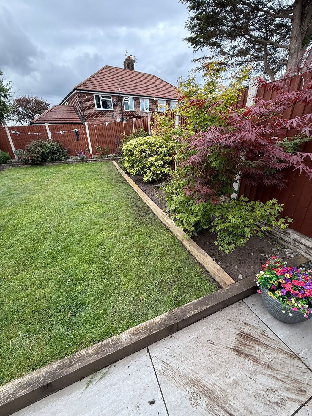 Patio area with planting and a freshly maintained lawn